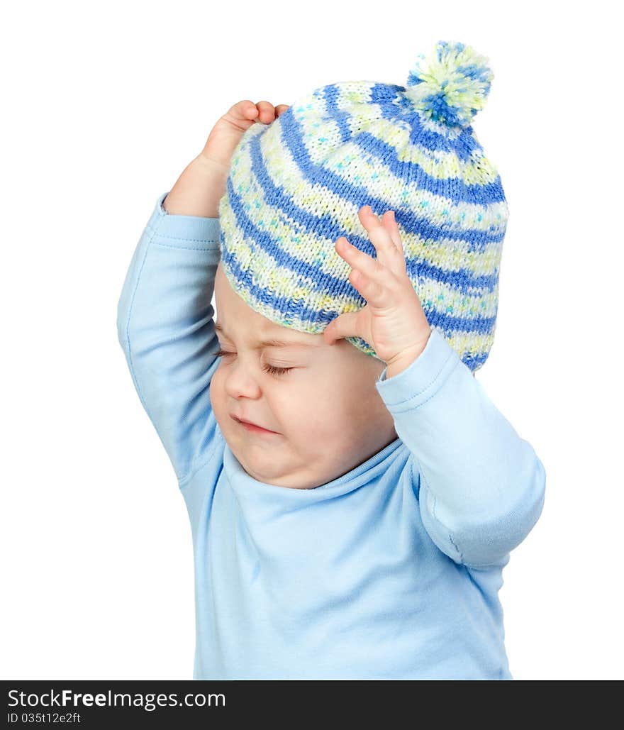 Angry baby taking off a wool cap