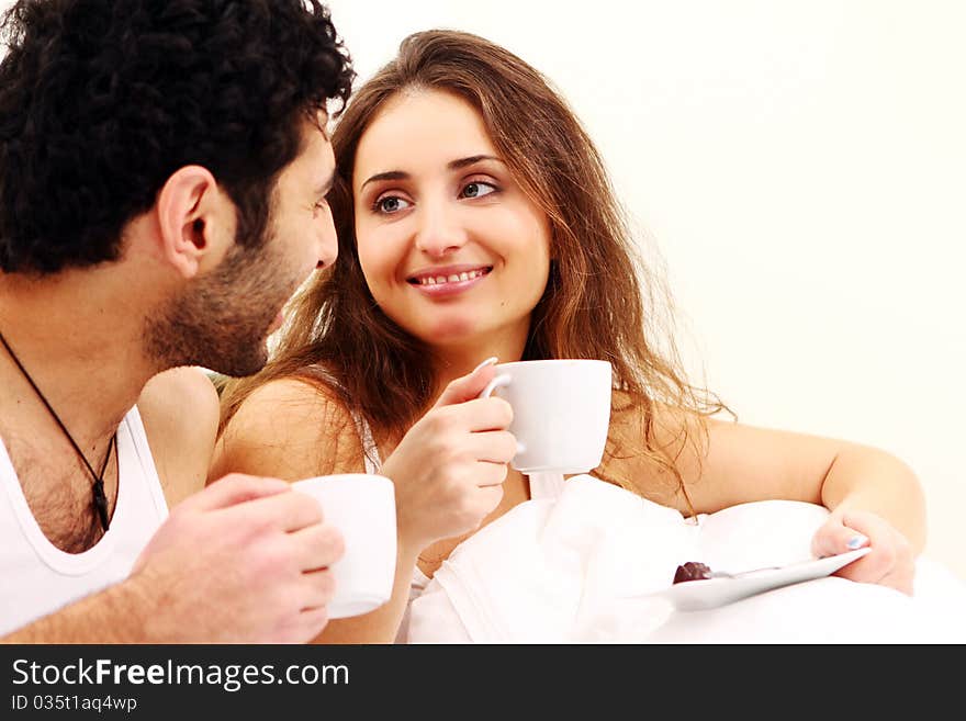 Young couple having breakfast in bed