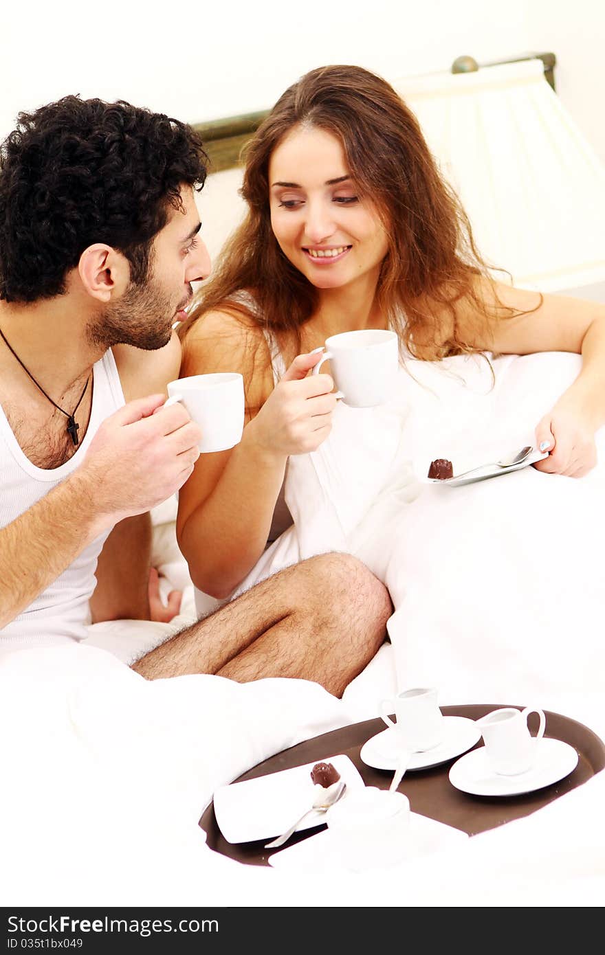 Young and beautiful couple having breakfast in bed. Young and beautiful couple having breakfast in bed