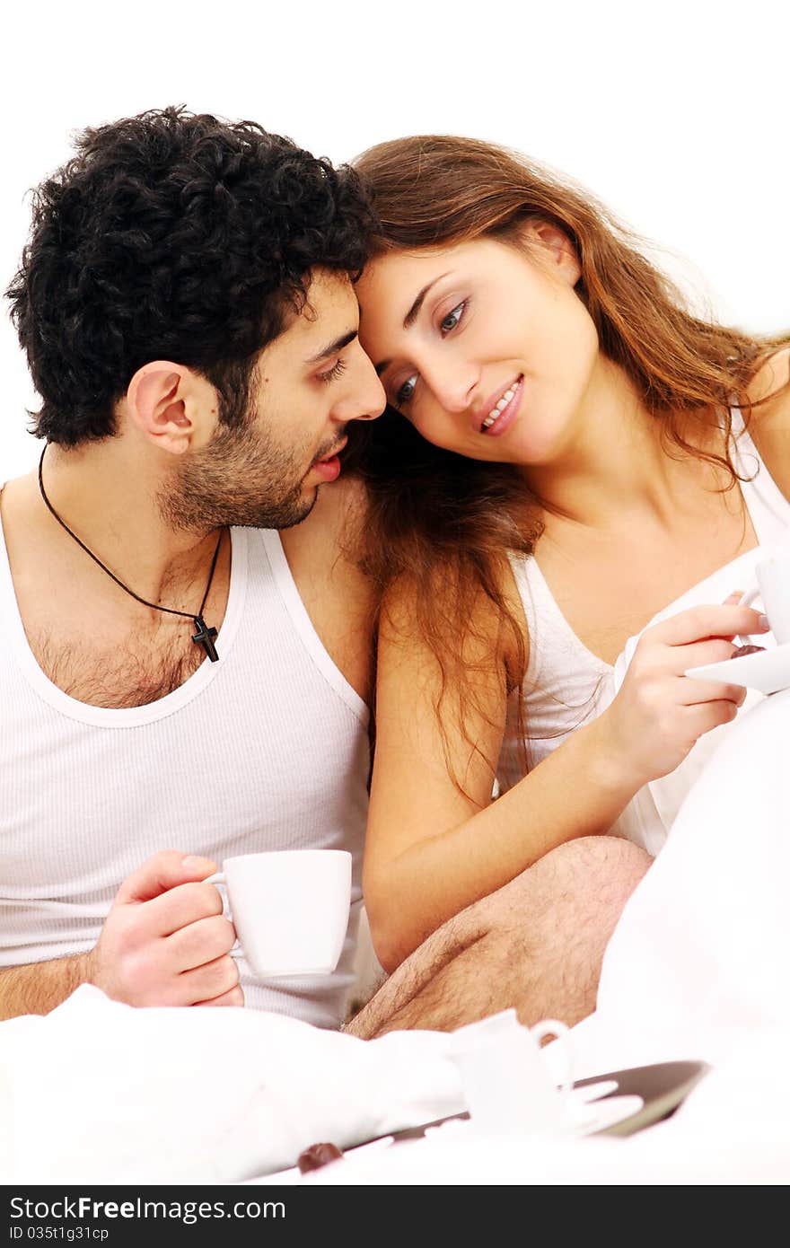 Young and beautiful couple having breakfast in bed. Young and beautiful couple having breakfast in bed