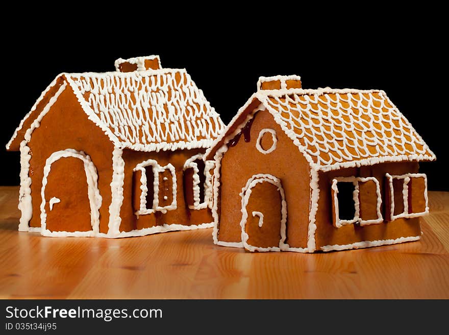 Two Isolated christmas gingernut house on wooden table