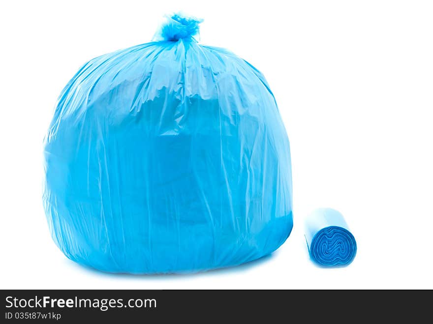 Tied blue garbage bag isolated on a white background.