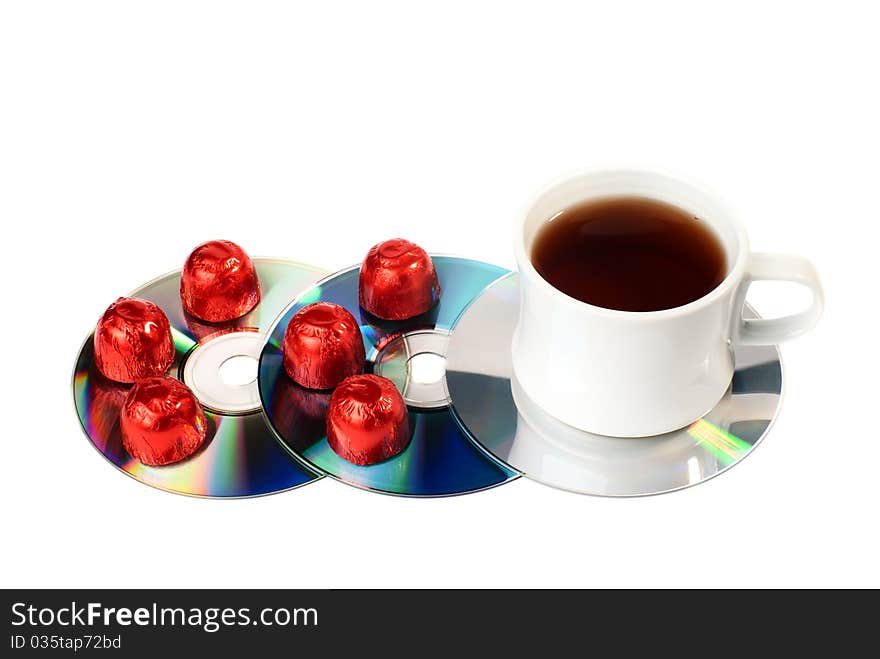 A cup of tea with sweets on CDs. Isolated on white background. A cup of tea with sweets on CDs. Isolated on white background.