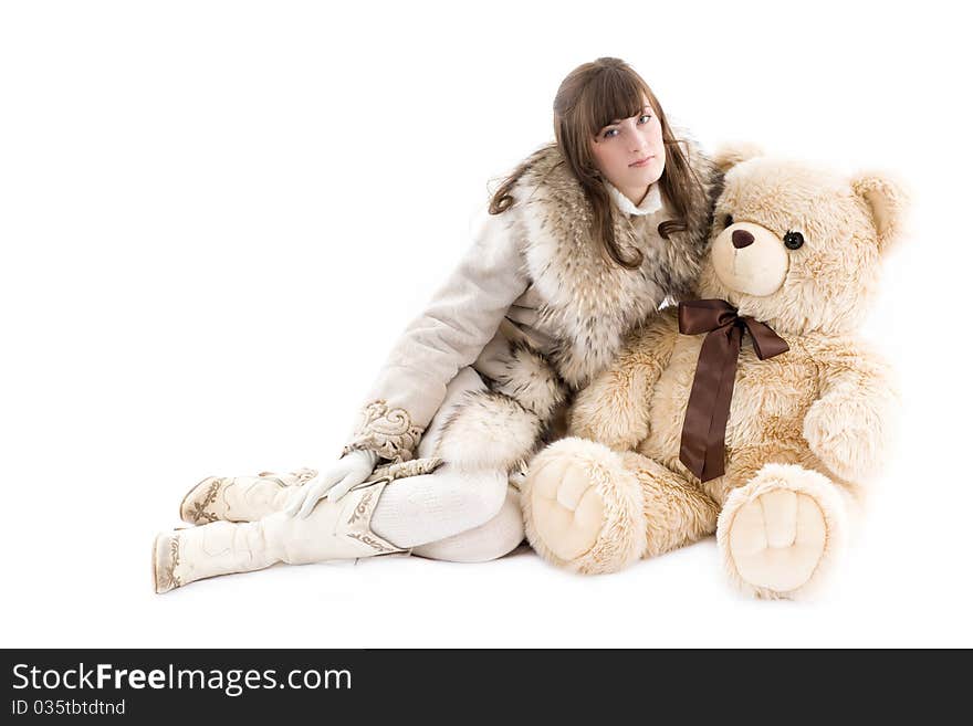 Girl in fur coat sitting with teddy bear