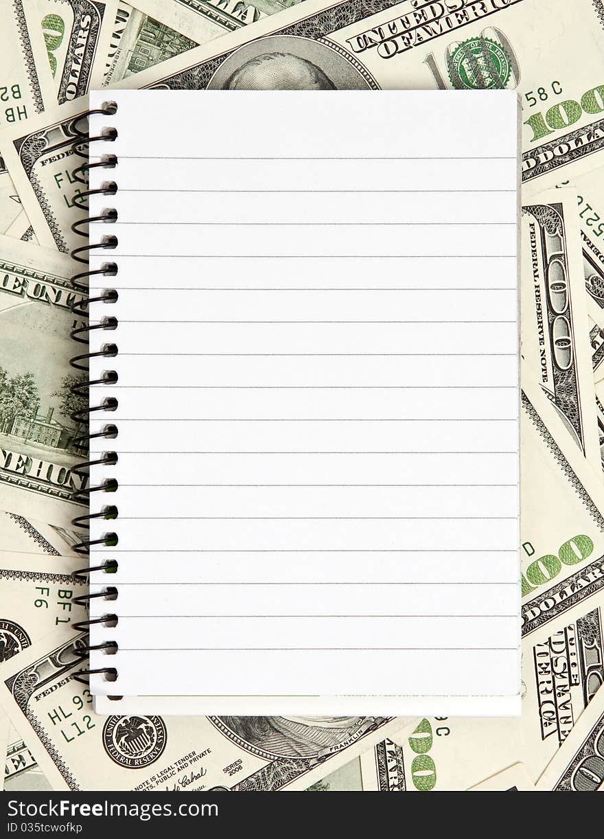 One white notepad on dollars background