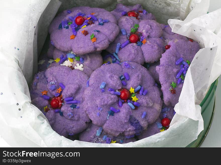 Purple spritz cookies in a tin