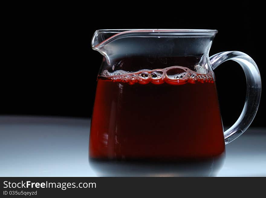 A glass is full of tea with black background. A glass is full of tea with black background.