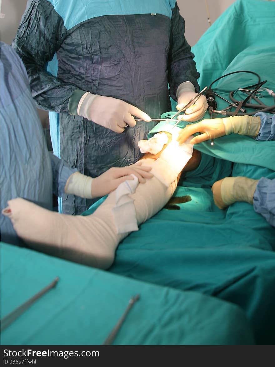 Surgeons holding medical instruments in hands and looking at patient. Surgeons holding medical instruments in hands and looking at patient