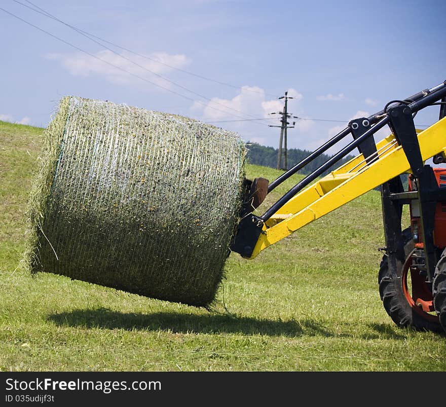 Tractor Working With A Hay Bale