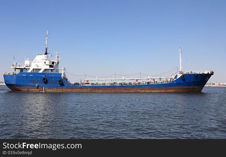 Cargo ship in water area of industrial harbour. Cargo ship in water area of industrial harbour