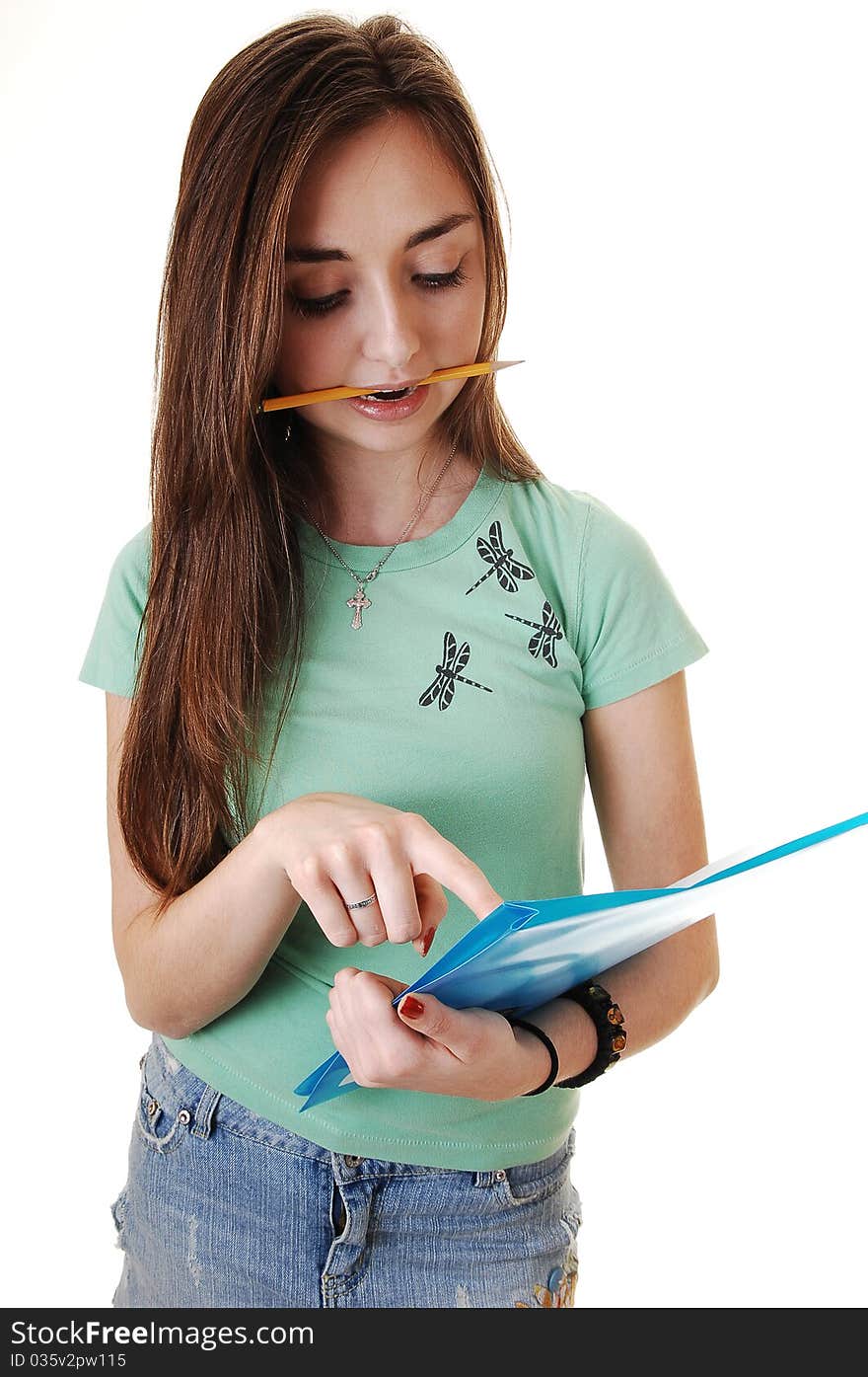 A pretty teenager in a green T-shirt and a blue short skirt, with long brunette 
hair, standing in the studio with a pencil in her mouth for white background. A pretty teenager in a green T-shirt and a blue short skirt, with long brunette 
hair, standing in the studio with a pencil in her mouth for white background.