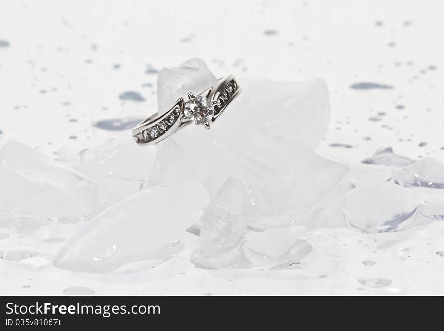 White Gold diamond engagement ring on ice cubes against a white background