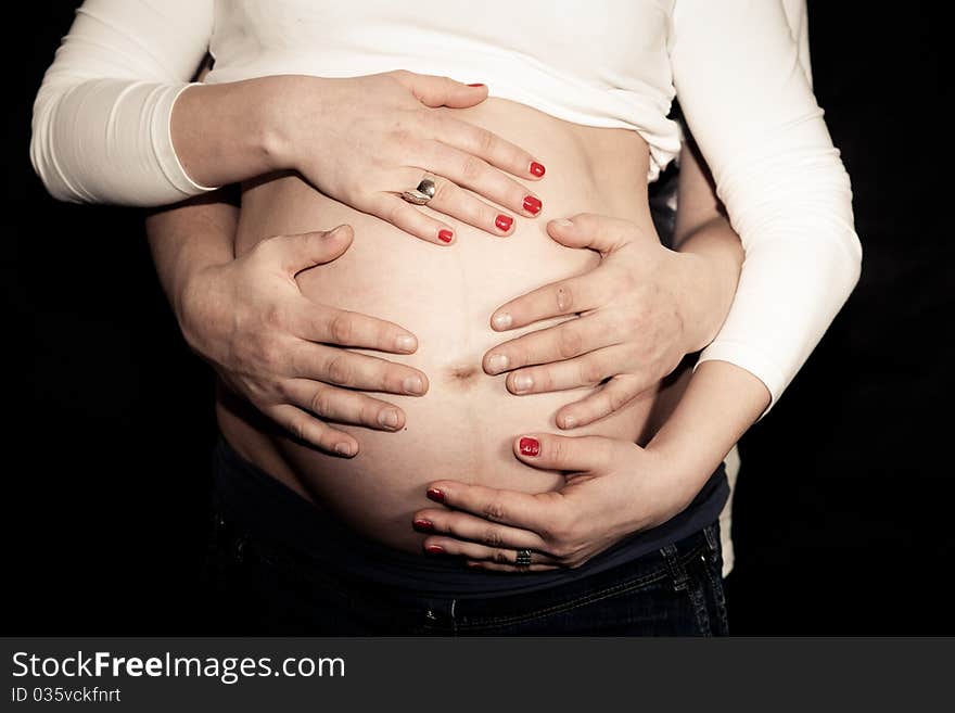 Pregnant belly with four hands. Pregnant belly with four hands