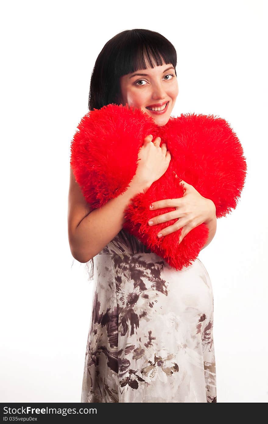 Young pregnant girl hugging a soft big heart