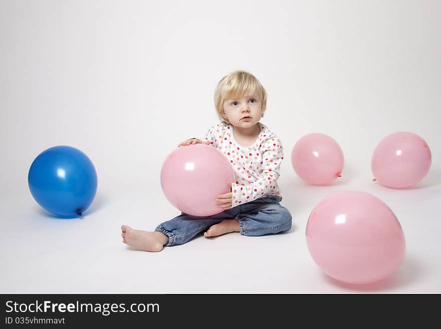 Portrait of cute girl with pink and blue balloons having fun at the party