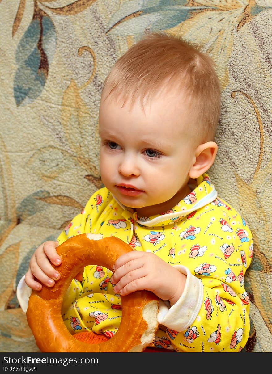 Little boy in yellow shirt who eats a bagel. Little boy in yellow shirt who eats a bagel