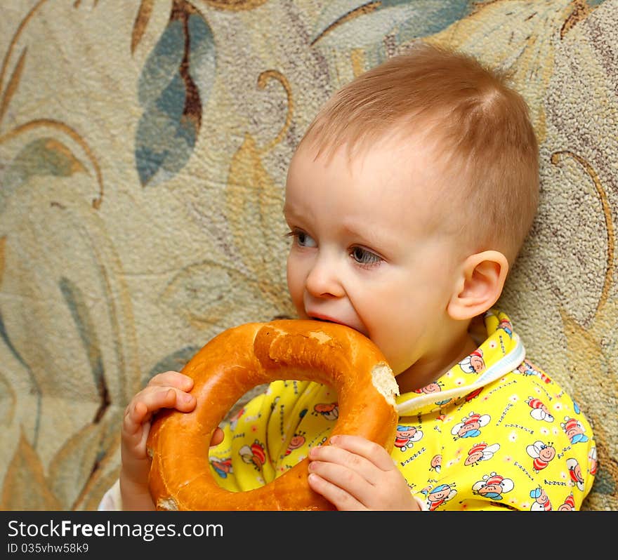 Little boy in yellow shirt who eats a bagel. Little boy in yellow shirt who eats a bagel