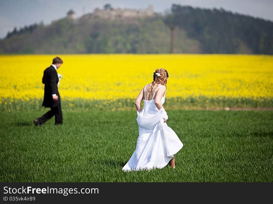 Young wedding couple - freshly wed groom and bride posing outdoors on their wedding day