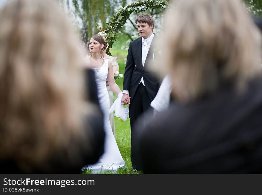 Young wedding couple - freshly wed groom and bride posing outdoors on their wedding day