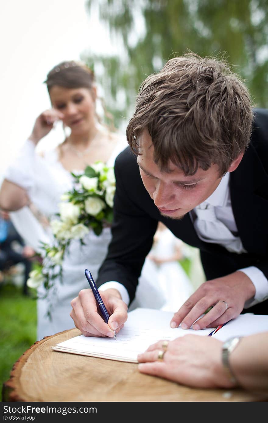 Young wedding couple - freshly wed groom and bride posing outdoors on their wedding day