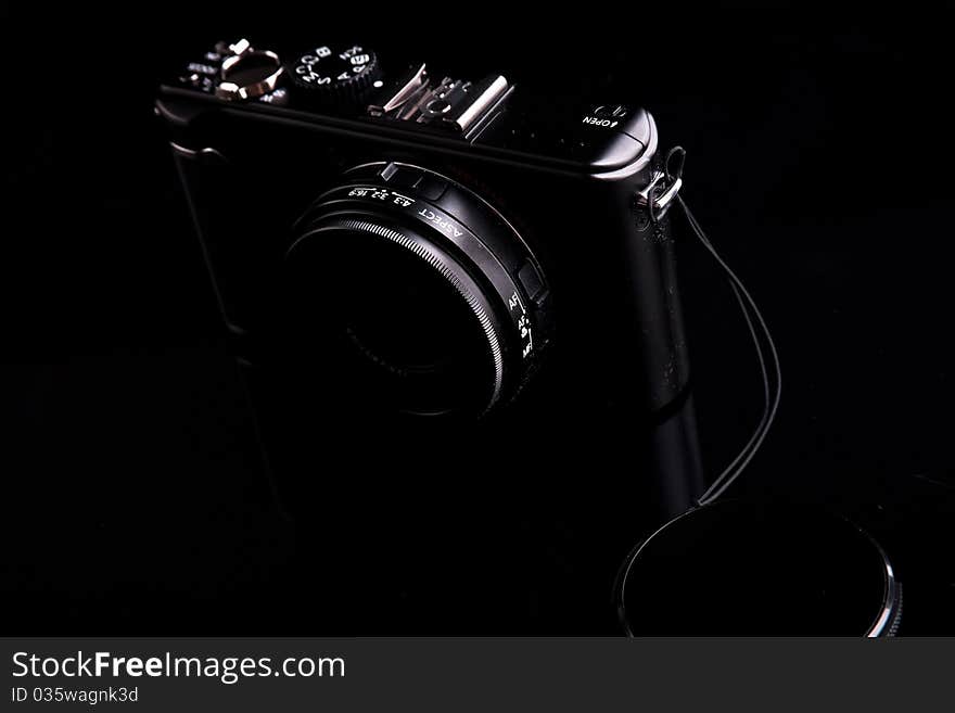 Black digital camera on dark backround