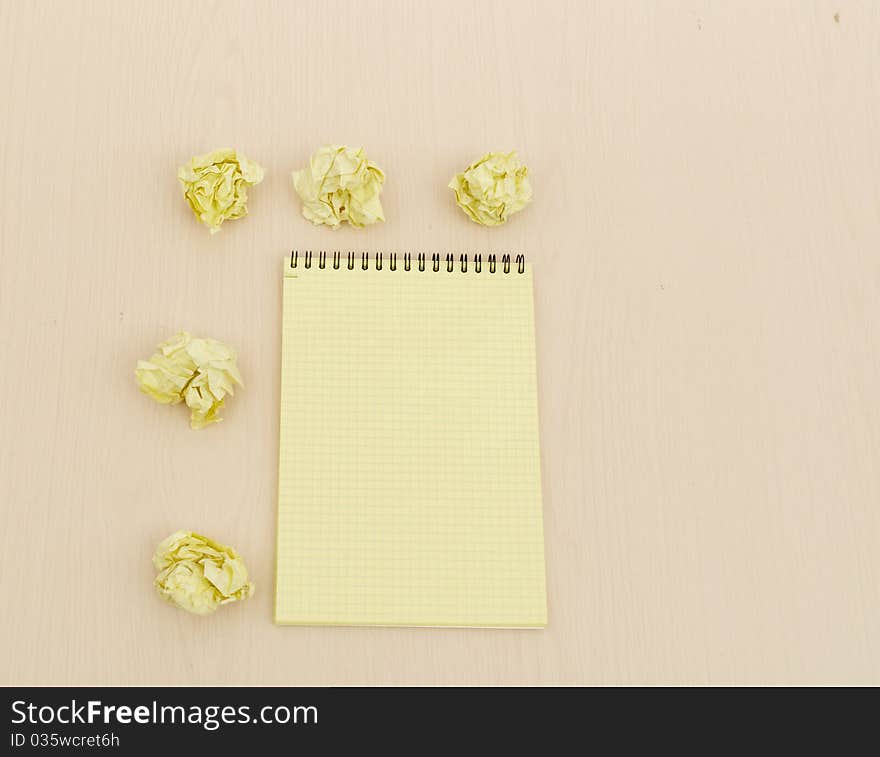 Notebook and crumpled paper on wooden table