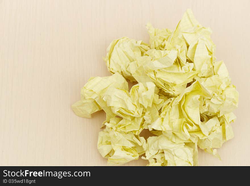 Yellow crumpled paper on wooden table background