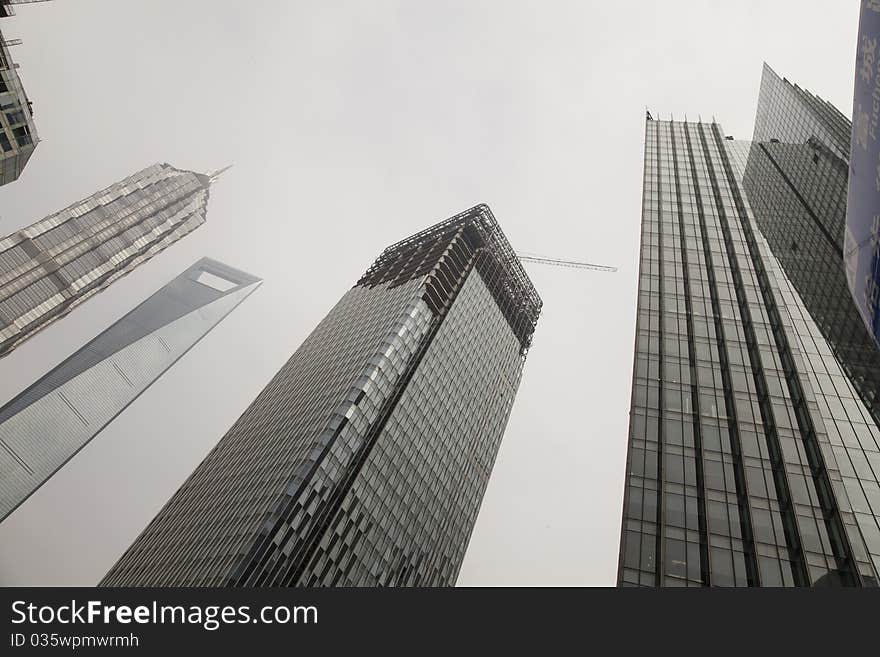 Shanghai / China:
Construction site of the new highest skyscraper, nickname dragon tail at Shanghais Pu dong Lujiazuui district (center), the Jinmao Tower and World Financial Center 0n the left background towering into the cloudy sky. Shanghai / China:
Construction site of the new highest skyscraper, nickname dragon tail at Shanghais Pu dong Lujiazuui district (center), the Jinmao Tower and World Financial Center 0n the left background towering into the cloudy sky.