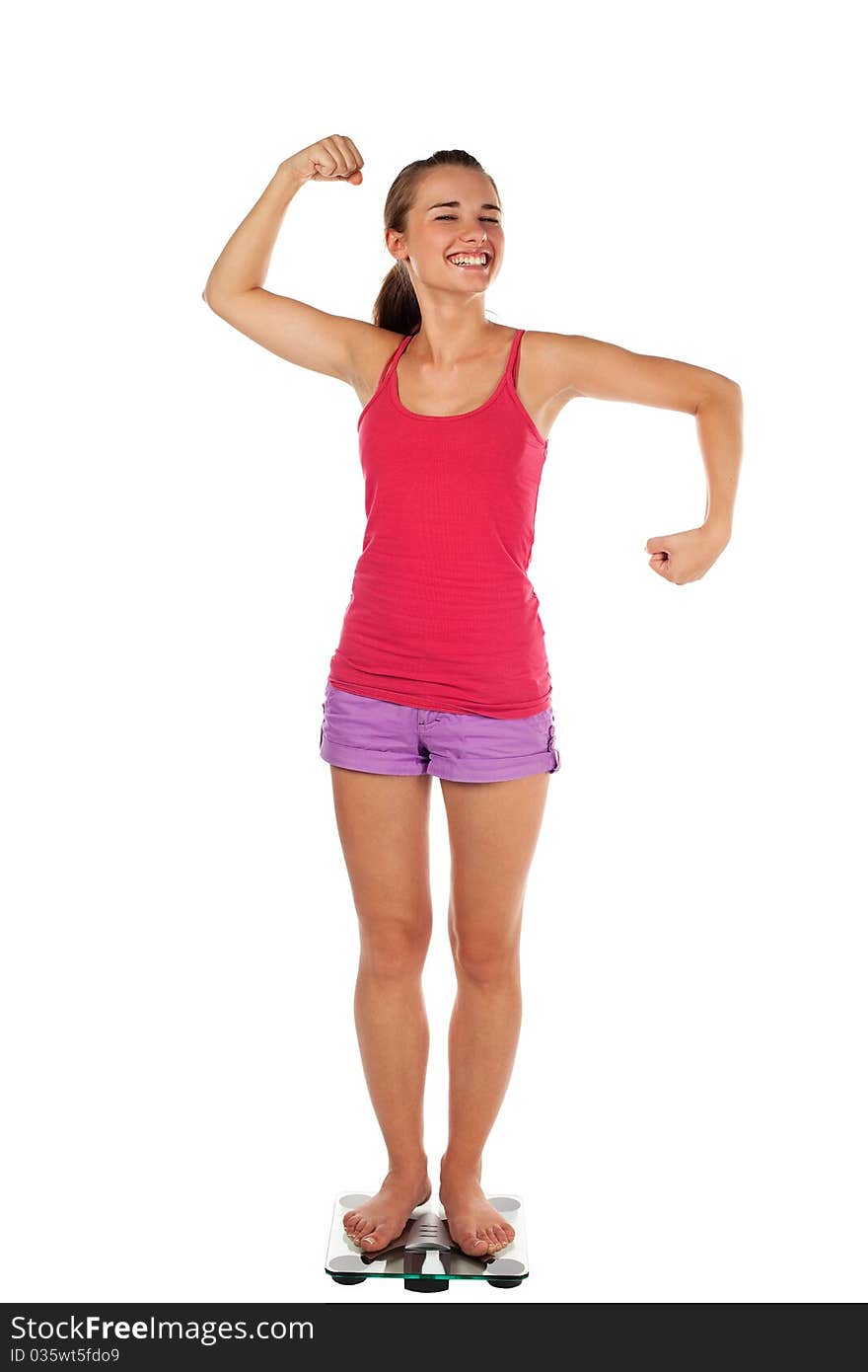 Young woman tense muscles on scale, smiling. Isolated on white