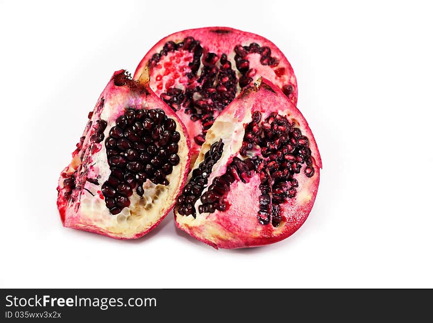 Pomegranate divided into parts isolated over white