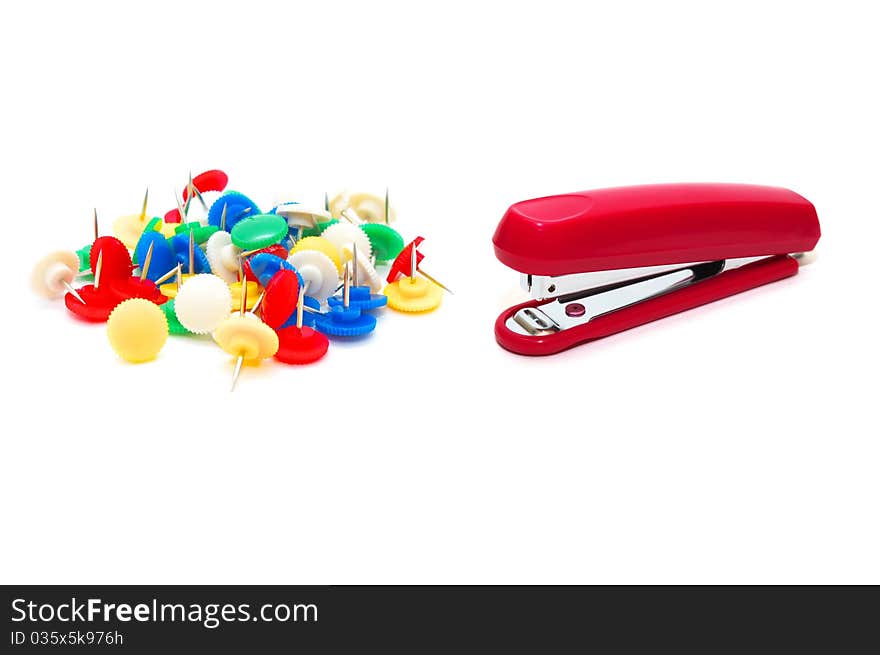 Photo of the red stapler with colour drawing pins on white background