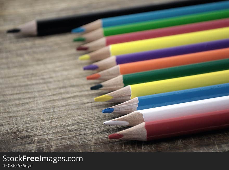 Colored pencils on the grunge desk. Colored pencils on the grunge desk