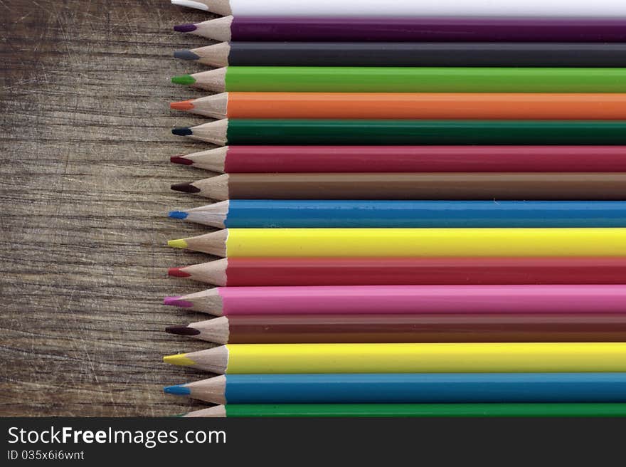 Colored pencils on the grunge desk. Colored pencils on the grunge desk