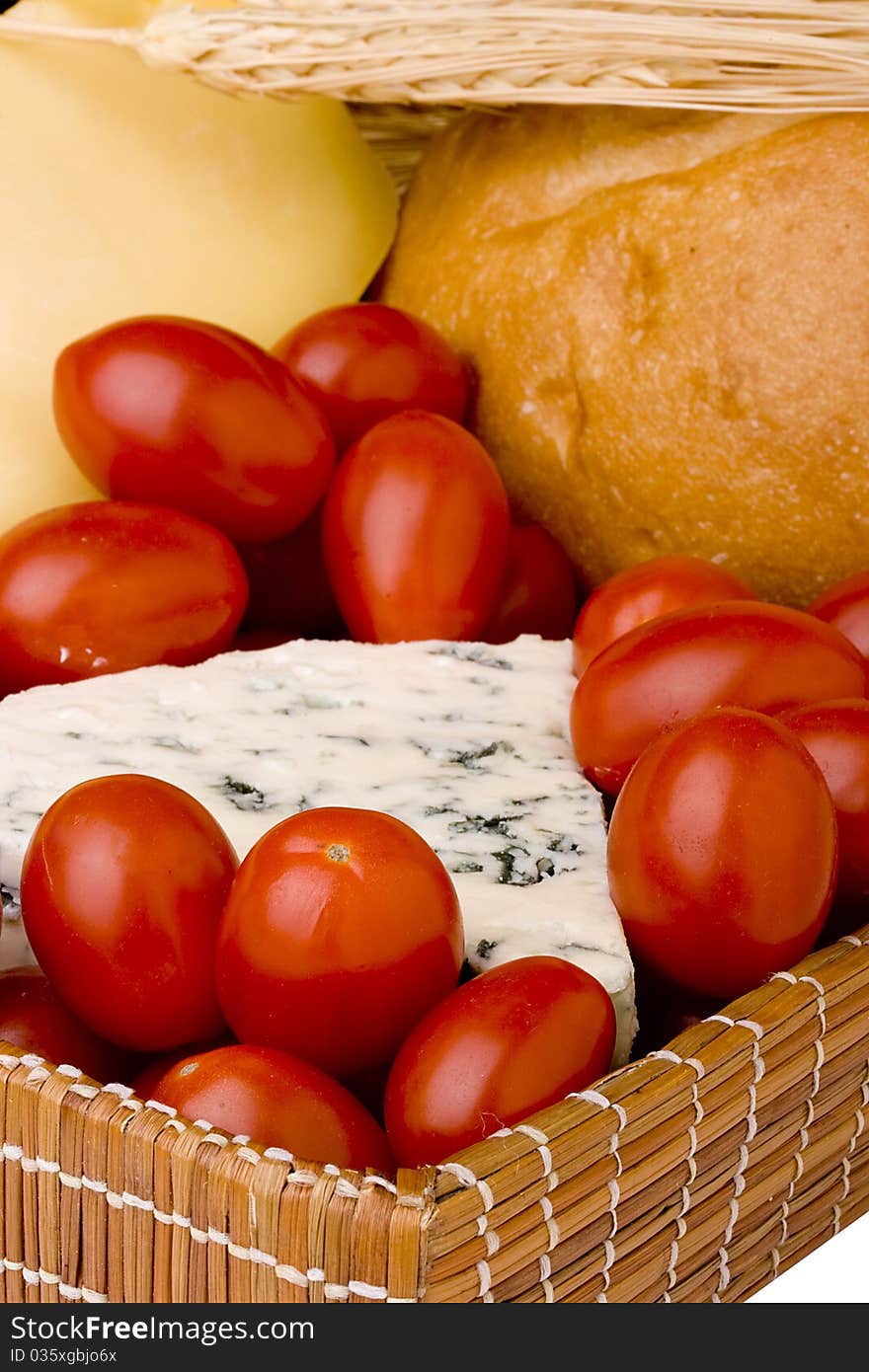 Slice of the Danish blue cheese with a mould among tomatoes.