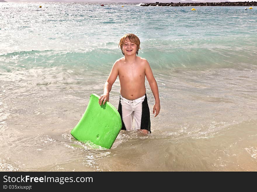 Boy has fun with the surfboard at the beach. Boy has fun with the surfboard at the beach