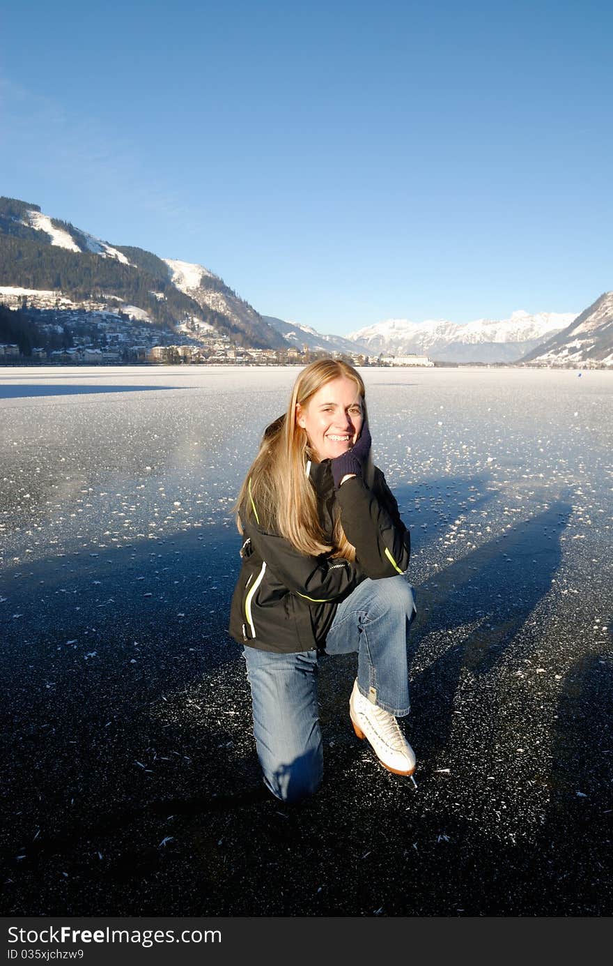 Young woman ice skating on frozen lake on a sunny day