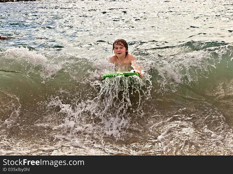 Boy has fun with the surfboard at the beach. Boy has fun with the surfboard at the beach