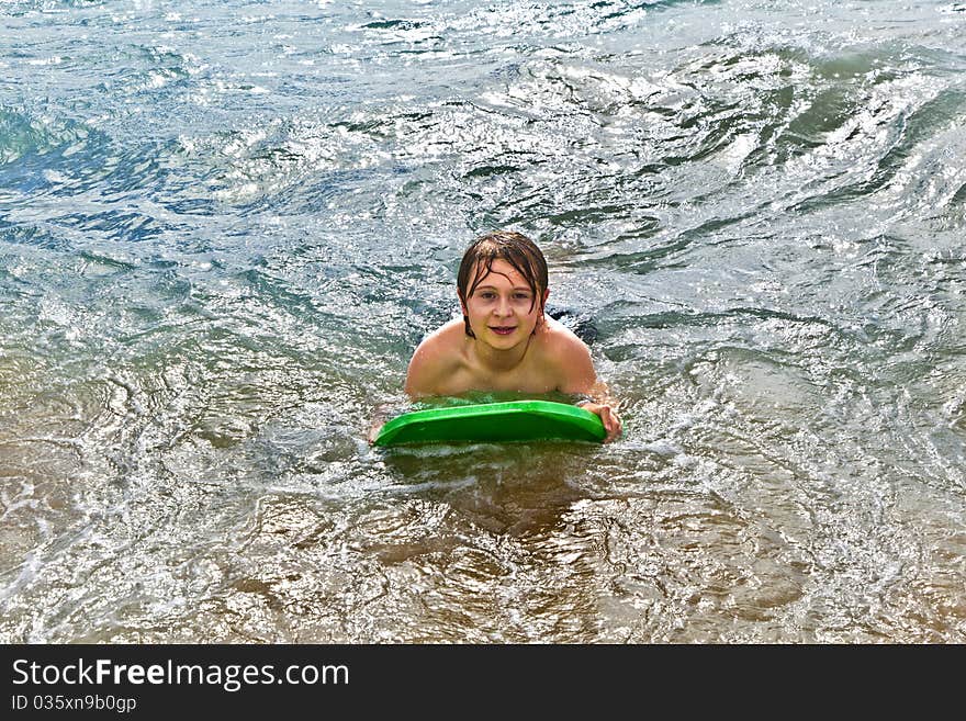 Boy has fun with the surfboard at the beach. Boy has fun with the surfboard at the beach