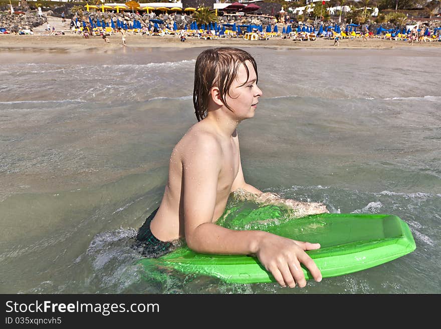 Boy has fun with the surfboard at the beach. Boy has fun with the surfboard at the beach