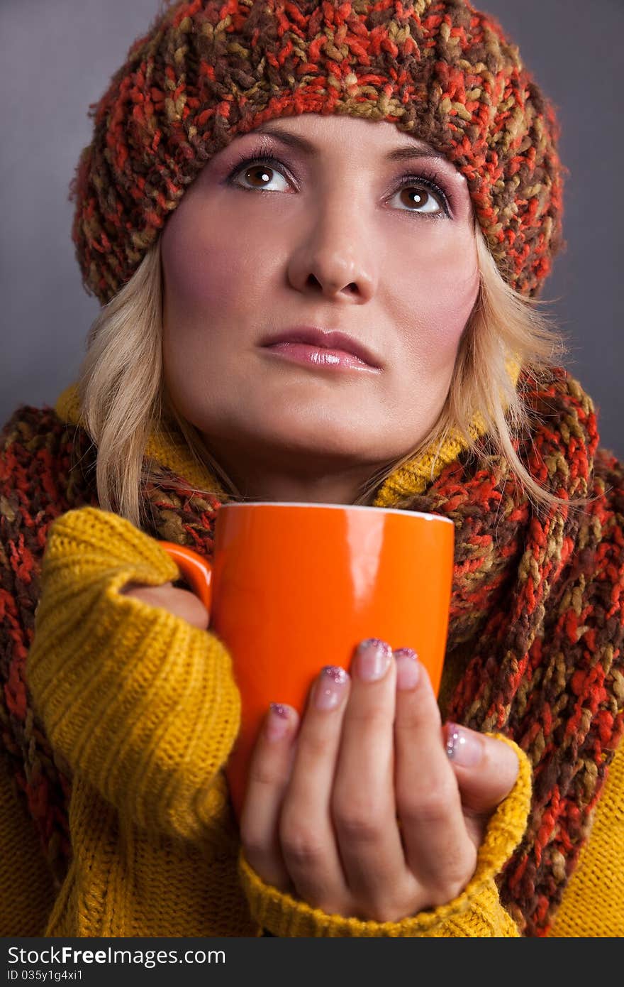 Beauty woman with an orange-colored cup