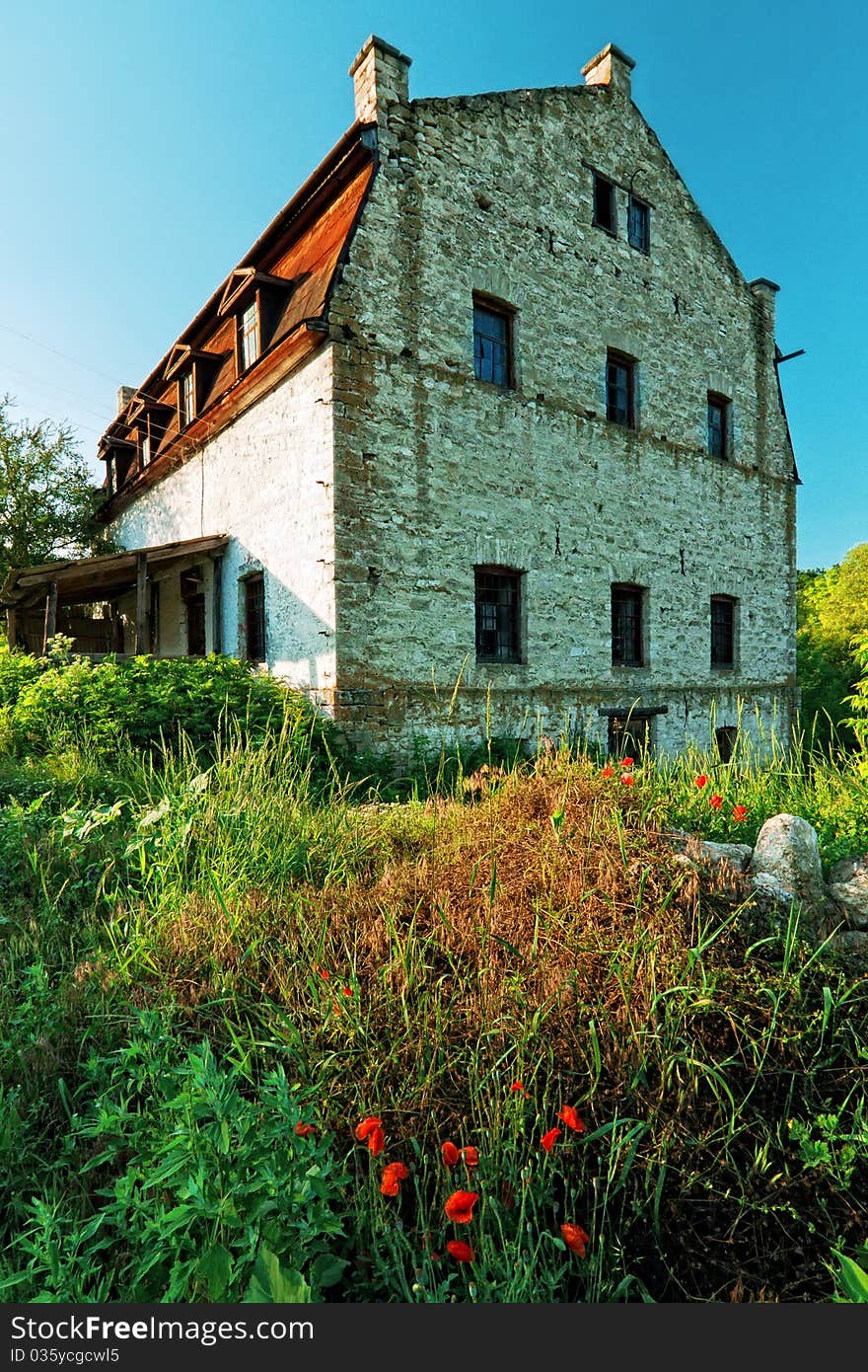 Old white three stored stone building in sunny summer day