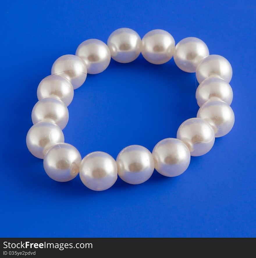 White isolated beads over blue background. Image. White isolated beads over blue background. Image.