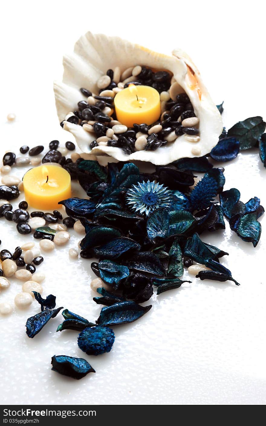 Yellow candles, blue potpourri and seashell on a white background. Yellow candles, blue potpourri and seashell on a white background