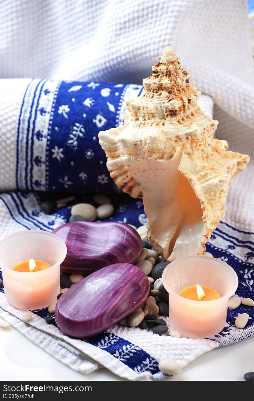 Seashell, candles and a soap placed on a towel. Seashell, candles and a soap placed on a towel