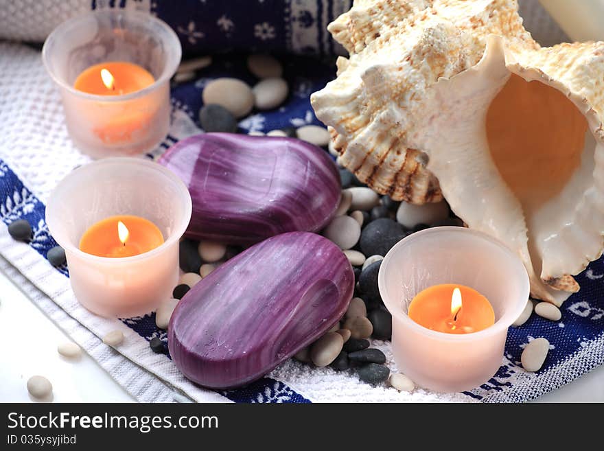 Seashell, candles and a soap placed on a towel. Seashell, candles and a soap placed on a towel