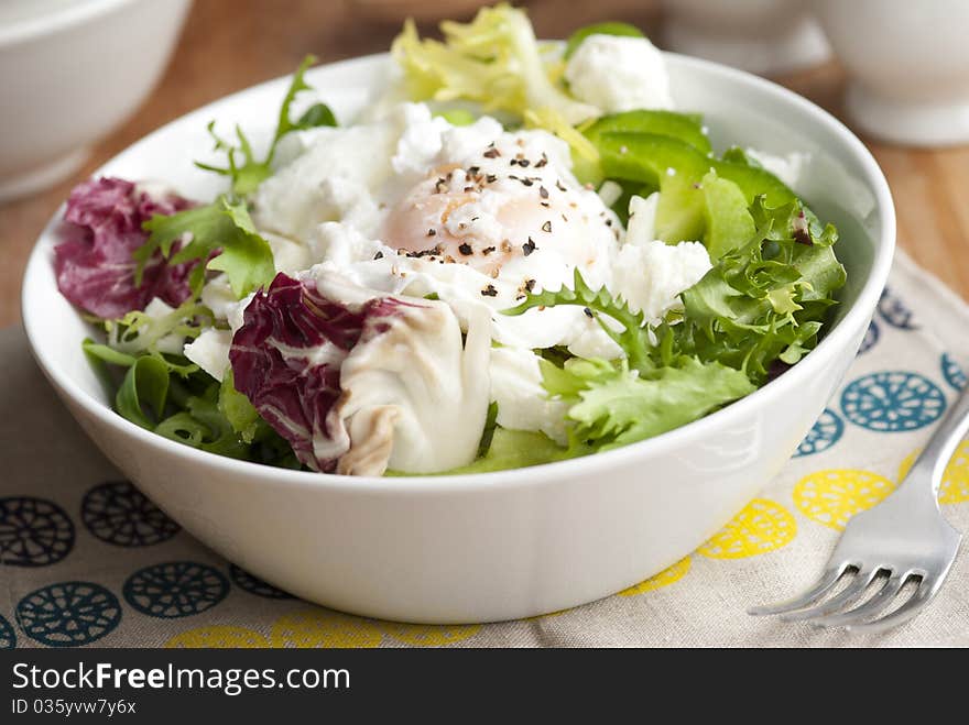 Leaf salad with feta cheese and poached egg