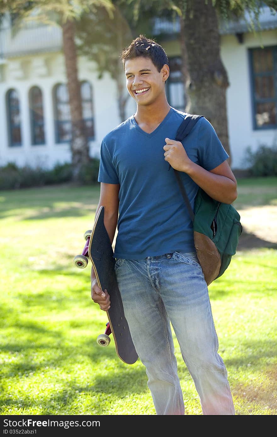 Student with skateboard and backpack outside school. Student with skateboard and backpack outside school