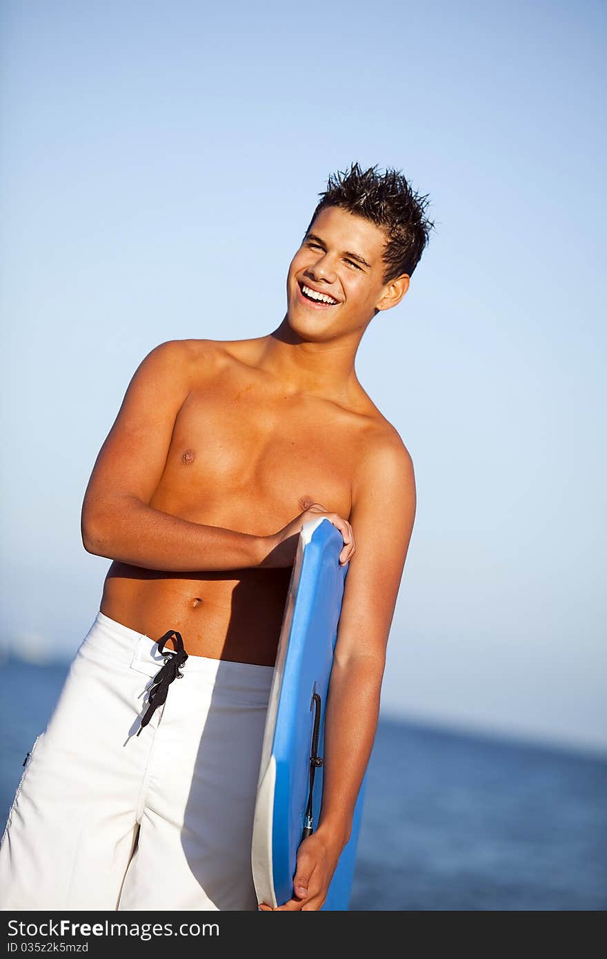 Young man at the beach with a boogie board. Young man at the beach with a boogie board