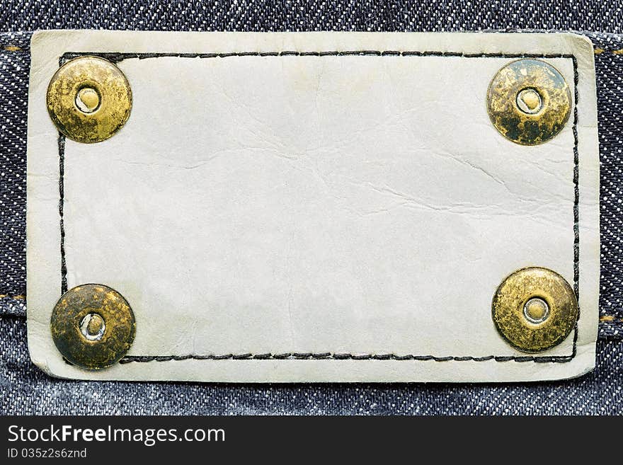 Frame for your text - closeup of blank white grungy artificial leather label with yellow metal rivets. Frame for your text - closeup of blank white grungy artificial leather label with yellow metal rivets