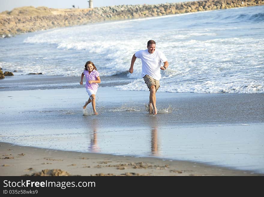 Father and daughter running at the beach